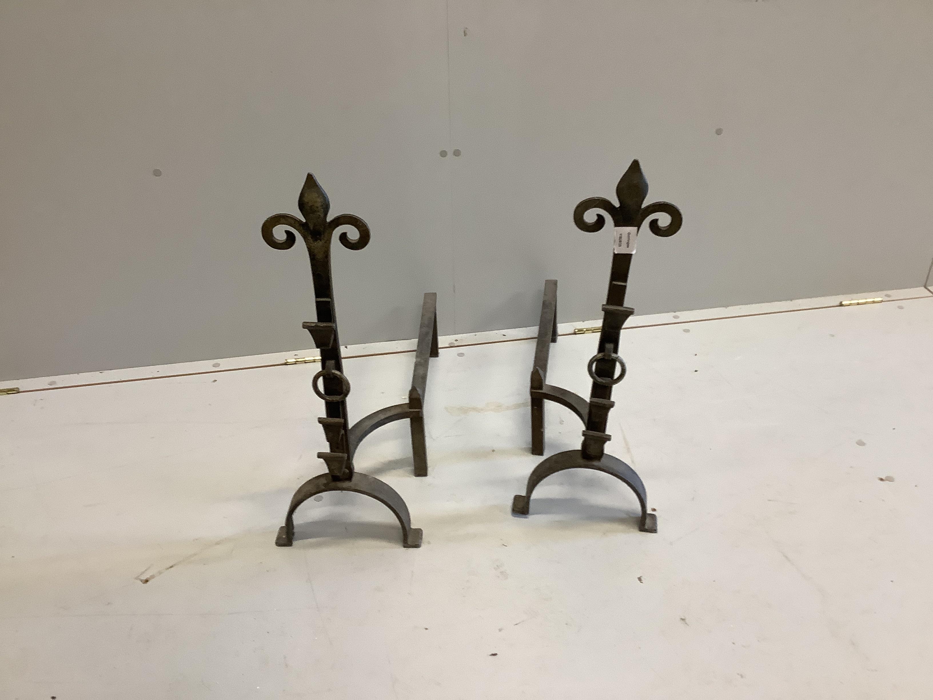 A pair of wrought metal fleur de lys firedogs, height 66cm